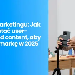 Kobieta nagrywa film telefonem na statywie, na tle biurka z kosmetykami.