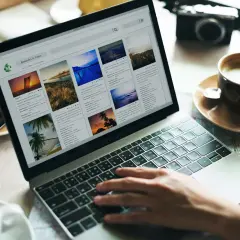 Osoba pisze na laptopie, przeglądając wpisy na blogu podróżniczym. Inspiracja, jak stworzyć blog osobisty na FB.