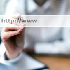 Dłoń pisze na ekranie wyszukiwarki "http://www.". Szukasz odpowiedzi, gdzie kupić domenę?