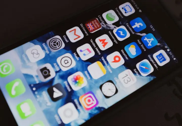 Ekran smartfona z ikonami aplikacji, w tym Facebook. Chcesz wiedzieć, jak sprawdzić czyjś numer telefonu na Facebooku?