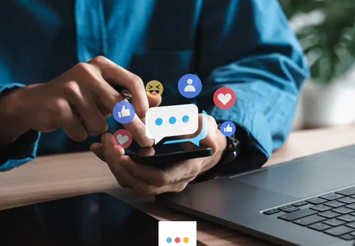 Ręce użytkownika na smartfonie, otoczone ikonami reakcji z Facebooka. Dowiedz się, jak wyróżnić post na Facebooku, by zdobyć więcej zaangażowania.