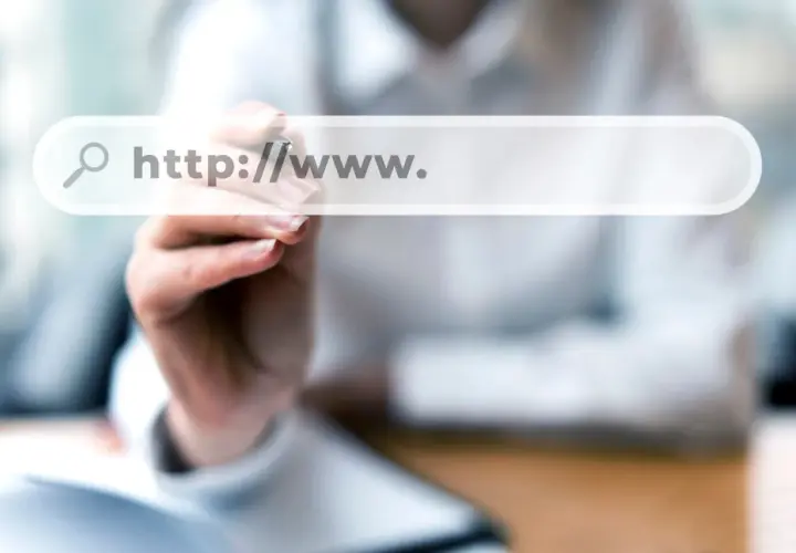 Dłoń pisze na ekranie wyszukiwarki "http://www.". Szukasz odpowiedzi, gdzie kupić domenę?
