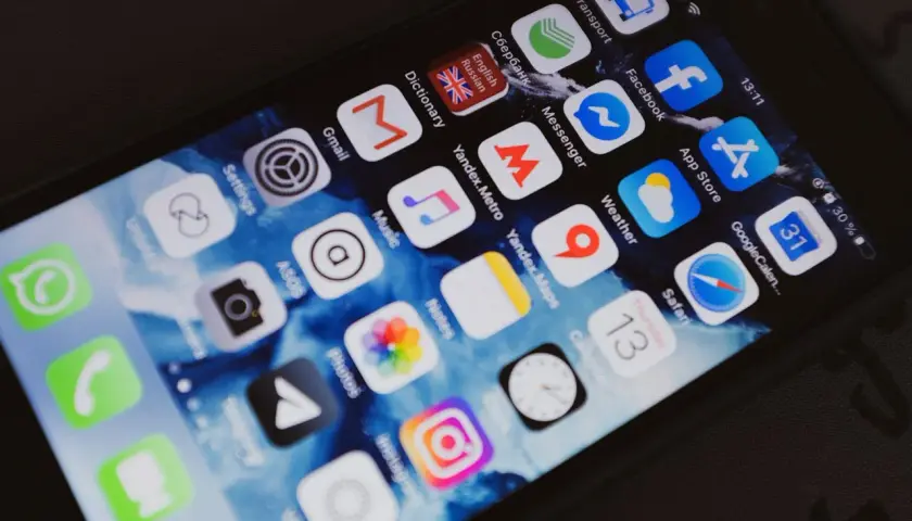Ekran smartfona z ikonami aplikacji, w tym Facebook. Chcesz wiedzieć, jak sprawdzić czyjś numer telefonu na Facebooku?
