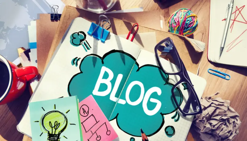 Notatnik z napisem "BLOG", kubek kawy, okulary i karteczki samoprzylepne. Jak zakończyć bloga po angielsku?