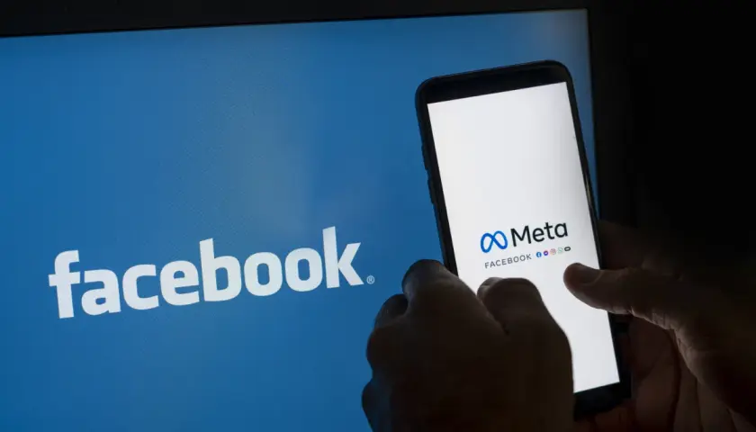 Ekran telefonu z logo Meta i Facebook obok niebieskiego ekranu z logo Facebook.