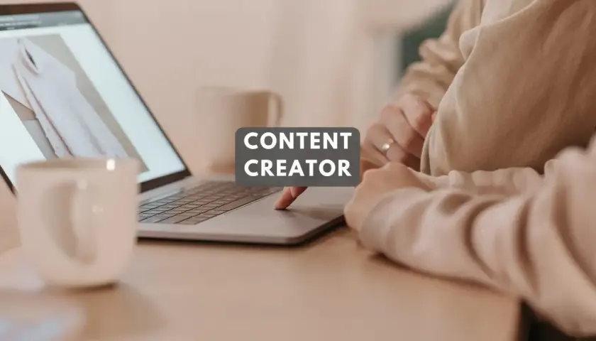 Content designer kto to? Osoba tworząca treści na laptopie, z kubkiem kawy obok.
