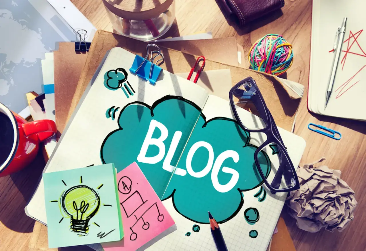 Notatnik z napisem "BLOG", kubek kawy, okulary i karteczki samoprzylepne. Jak zakończyć bloga po angielsku?