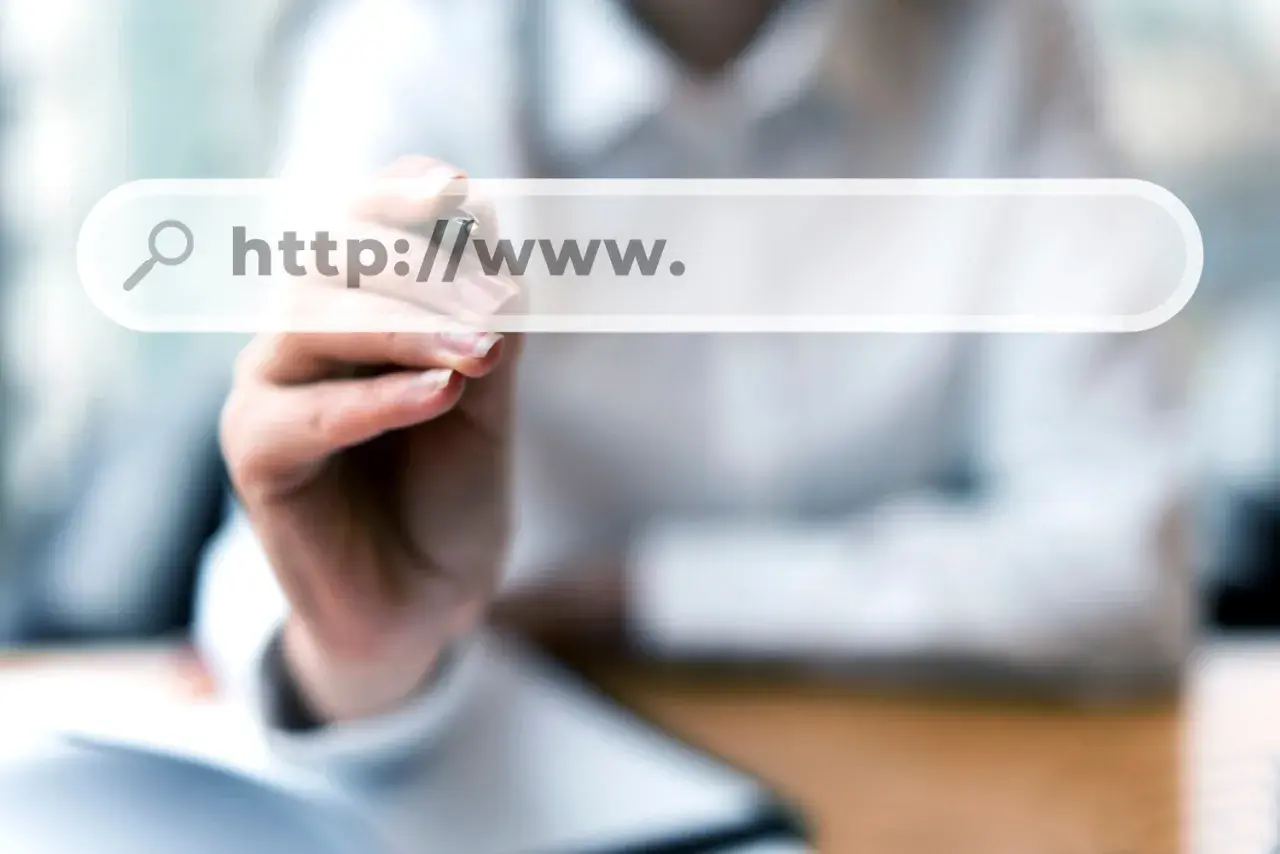 Dłoń pisze na ekranie wyszukiwarki "http://www.". Szukasz odpowiedzi, gdzie kupić domenę?