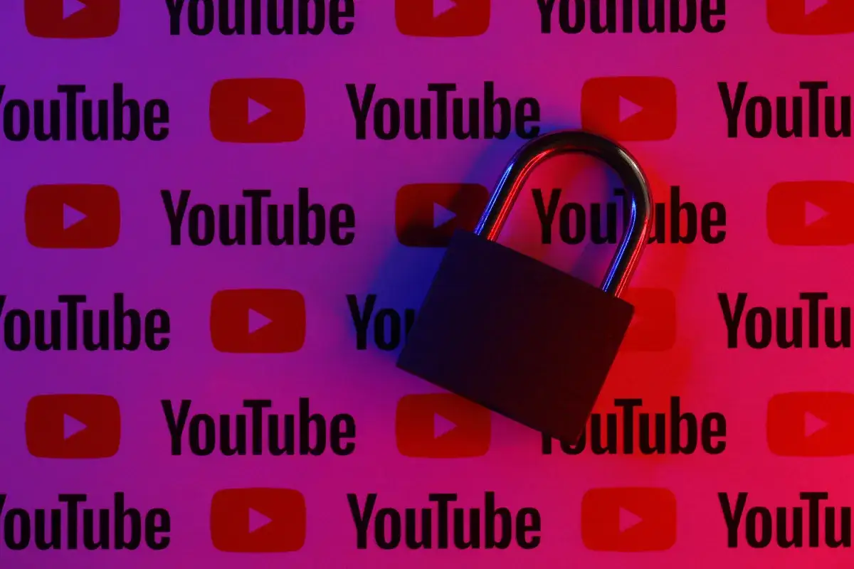 Kł&oacute;dka na tle logo YouTube. Dowiedz się, jak zablokować YouTube w przeglądarce, aby ograniczyć dostęp.