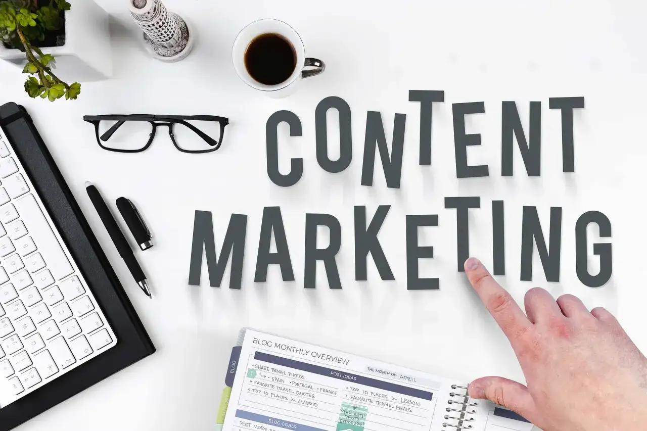 Content SEO Manager do czego służy? Planowanie i tworzenie treści, by przyciągnąć odbiorców. Na biurku klawiatura, okulary, kawa i notatnik.