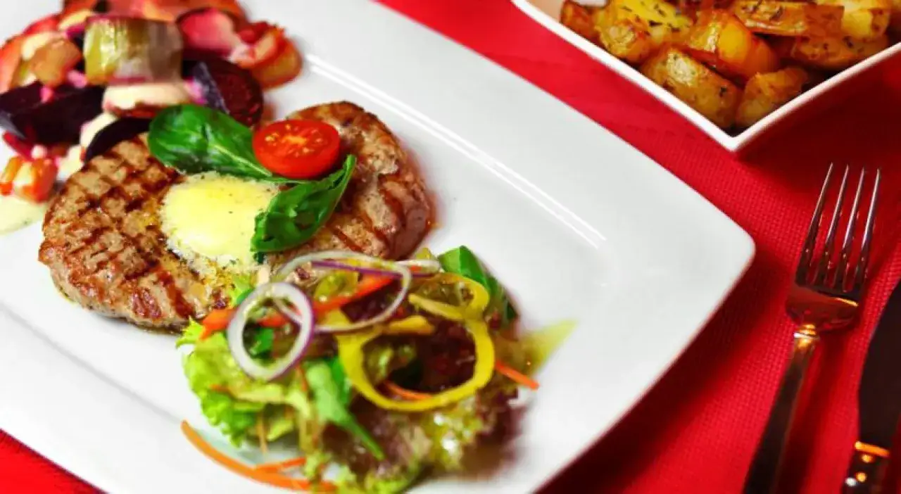 Pyszny obiad w Szczecinie: grillowany kotlet z masłem, sałatka i pieczone ziemniaki. Idealne miejsce, gdzie zjeść w Szczecinie, blog poleca!